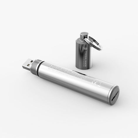 A metallic silver cylindrical USB flash drive lying horizontally, with a small matching metallic cylindrical keychain bottle and ring standing behind it on a clean white background.